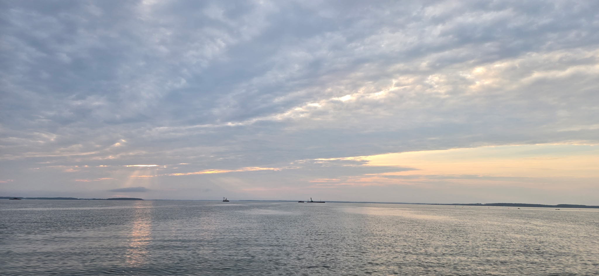 Soft sunlight filtering through clouds over peaceful open water
